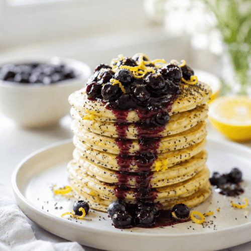 Lemon poppyseed fluff pancakes topped with warm blueberry compote and a sprinkle of lemon zest